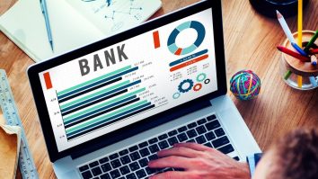 Bărbat în fața laptopului cu o cafea în mână