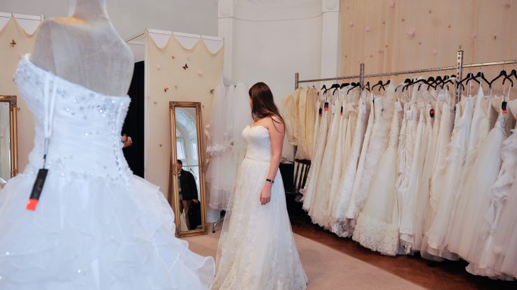 o mireasa probeaza o rochie de nunta