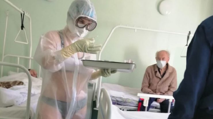 O infirmieră din Rusia are grijă de pacienții cu Covid-19, în lenjerie intimă – sub echipamentul transparent