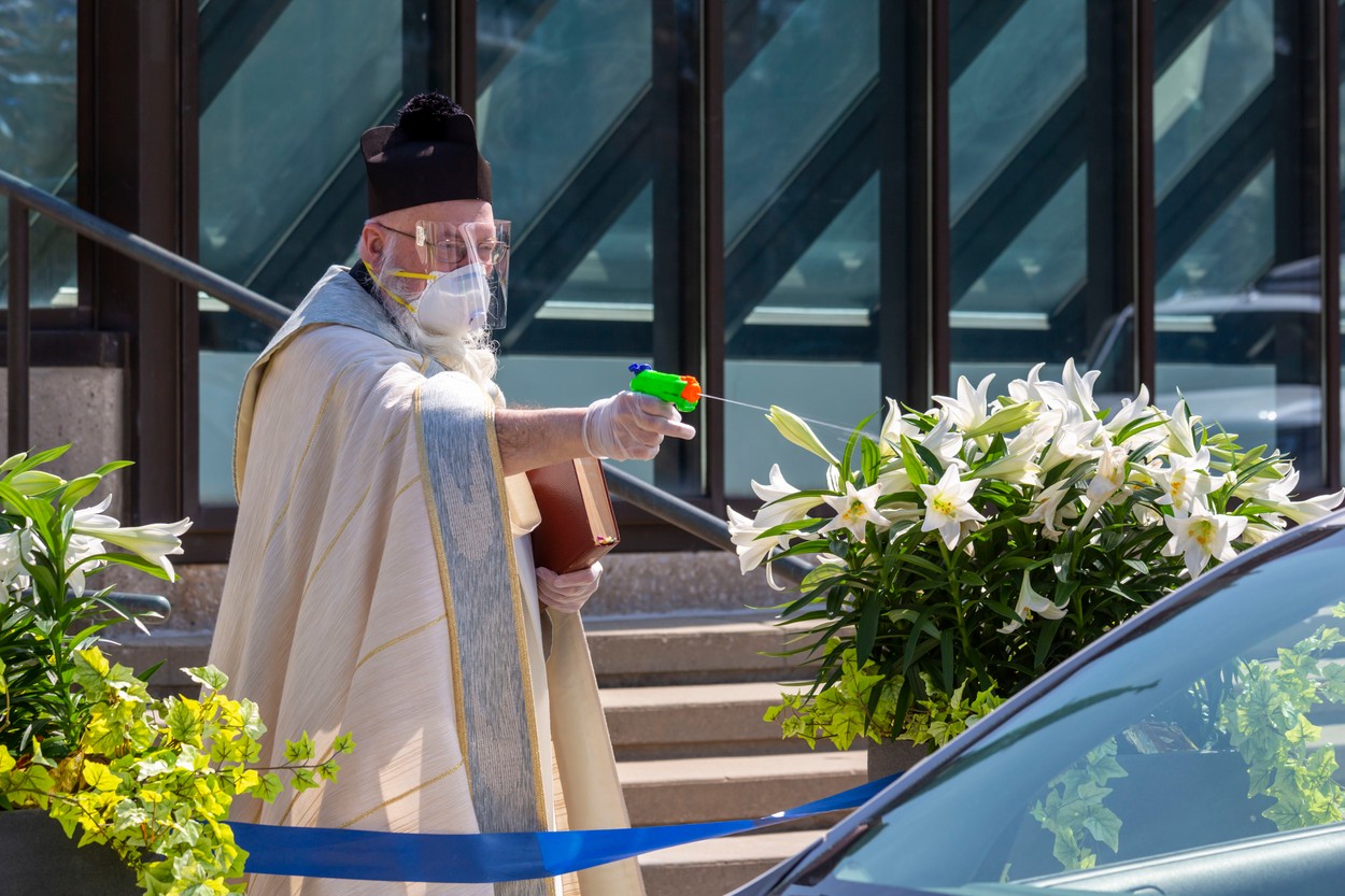 Un preot „îi binecuvântează“ pe credincioși cu un pistol de jucărie. Avalanșă de glume online