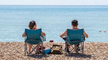 doi tineri stau pe sezlong la plaja