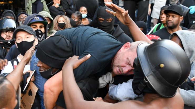 O imagine cât o mie de cuvinte. Un afro-american cară un alb rănit din grupa rivală