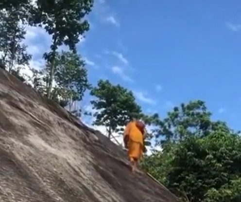 În timp ce un grup de alpiniști se chinuie să urce o stâncă abruptă, un călugăr trece cu viteză pe lângă ei