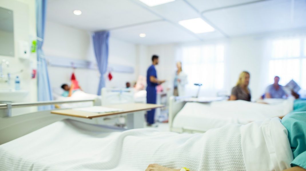 Bărbat întins pe patul de spital așteptând transplant