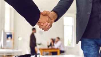 Două persoane care dau mâna