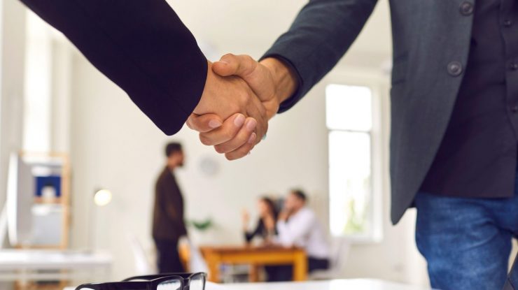 Două persoane care dau mâna