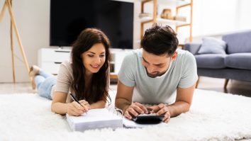 doi tineri care calculeaza un buget intr-o casa noua.