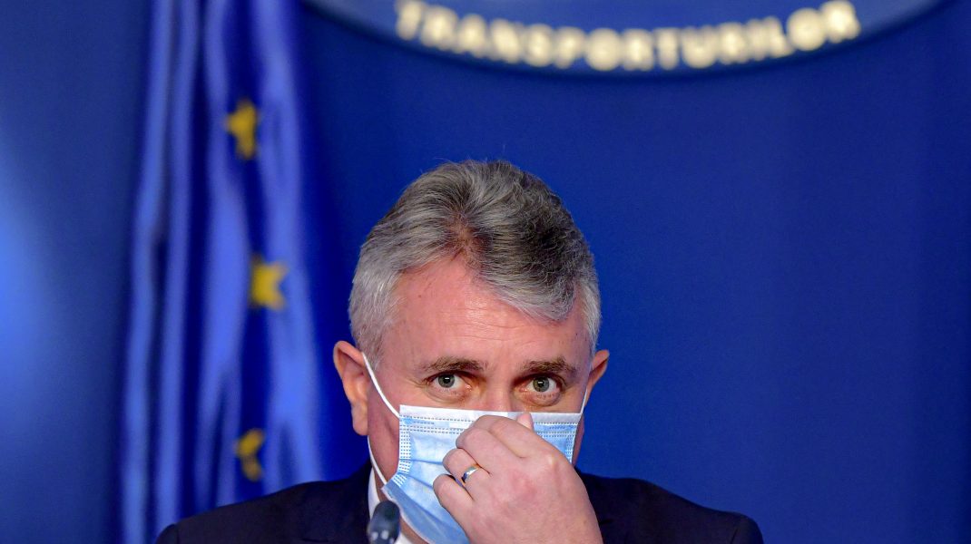 Lucian Bode privește spre cameră, în timp ce-și aranjează masca de protecție.