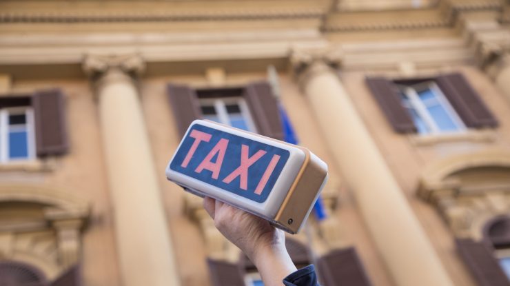 semn de taxi tinut in mana la un protest