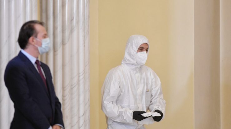 Scene inedite la depunerea jurământului: un bărbat dezinfectează pupitrul miniștrilor îmbrăcat în combinezon de ambulanță