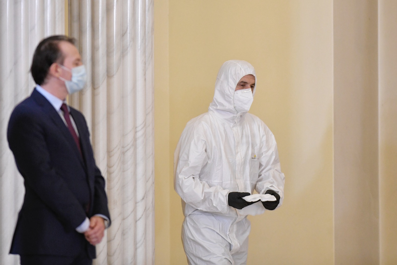 Scene inedite la depunerea jurământului: un bărbat dezinfectează pupitrul miniștrilor îmbrăcat în combinezon de ambulanță