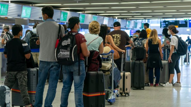 Oameni care stau la coadă în aeroport.