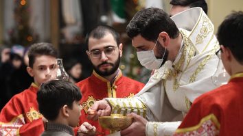 6427235 24.12.2020 A Catholic priest gives communion to a worshipper during a Catholic Christmas eve mass at the Cathedral of the Immaculate Conception, in Moscow, Russia.,Image: 578538193, License: Rights-managed, Restrictions: , Model Release: no