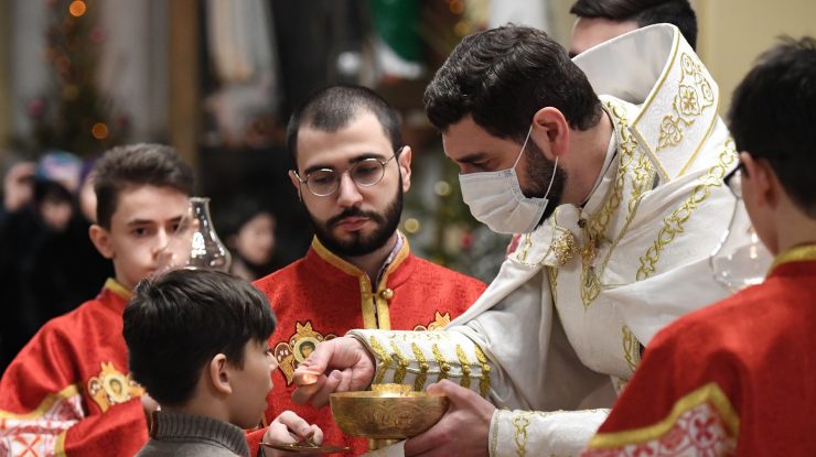 6427235 24.12.2020 A Catholic priest gives communion to a worshipper during a Catholic Christmas eve mass at the Cathedral of the Immaculate Conception, in Moscow, Russia.,Image: 578538193, License: Rights-managed, Restrictions: , Model Release: no