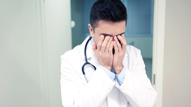 Doctor care își pune mâinile la ochi.