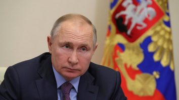 vladimir putin cu steagul rusiei in spate.