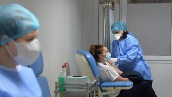 Două asistente și un pacient într-un loc special amenajat pentru vaccinare.