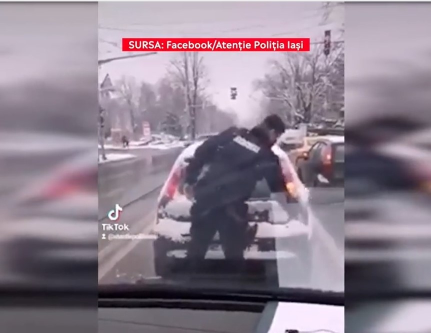 Un jandarm a curățat zăpada de pe luneta unui mașini din trafic. Reacțiile apărute: „Șoferul trebuia amendat“
