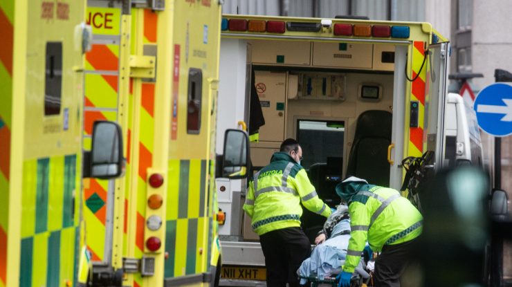 un pacient cu covid este urat intr-o ambulanta, in marea britanie.