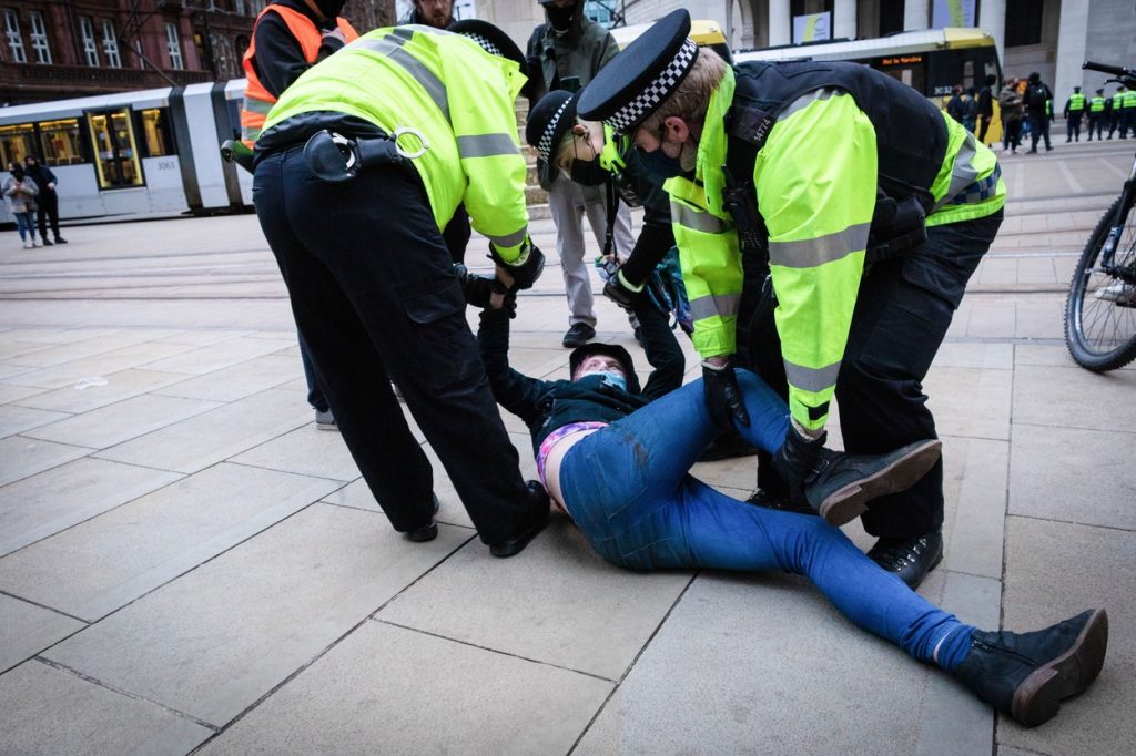 Imaginile care au stârnit indignare. O femeie a fost dezbrăcată și târâtă de poliție, în timpul unui protest din Manchester