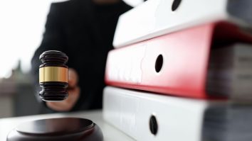 ciocanel de judecator langa dosare de solutionat.