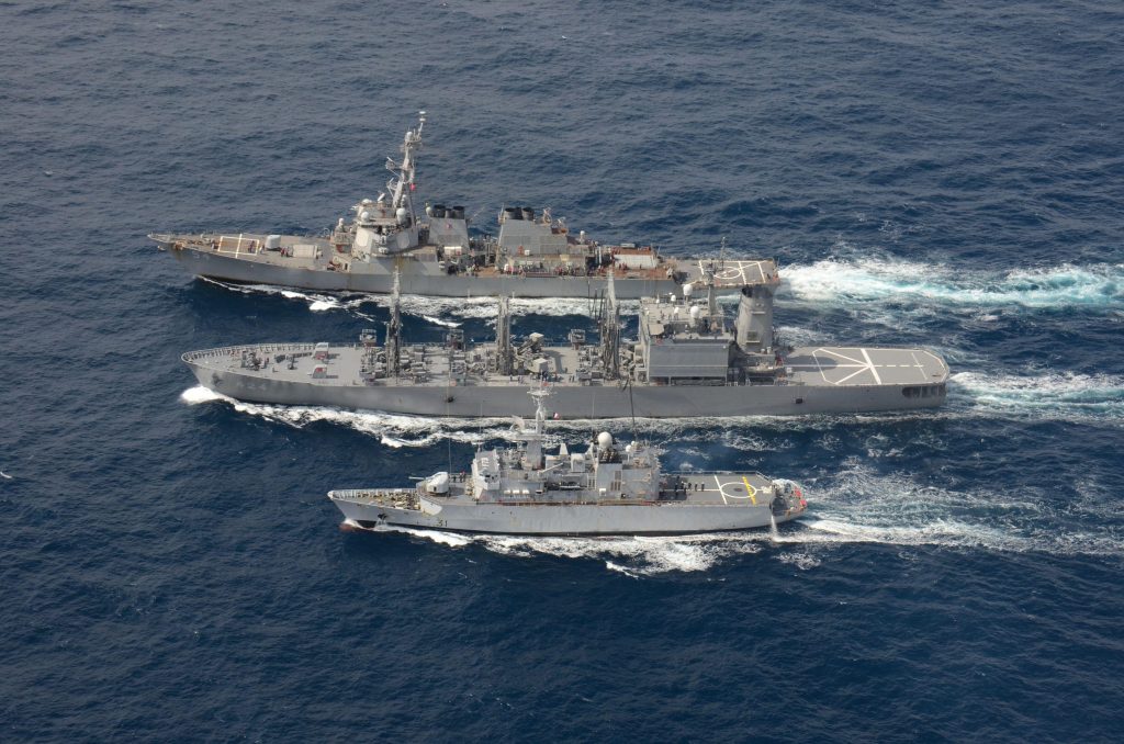 The U.S. Navy Arleigh Burke-class guided-missile destroyer USS Curtis Wilbur, top, conducts a replenishment-at-sea with the Japan Maritime Self-Defense Force Towada-class replenishment ship JS Hamana, center, and French Floreal-class light frigate FNS Pra