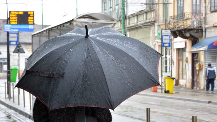 o femeie tine o umbrela in ploaie.