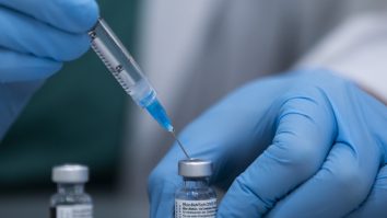 Asistentă care pregătește o doză de vaccin Pfizer.