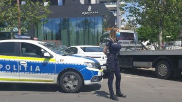 politista sexy in fata masinii de politie.