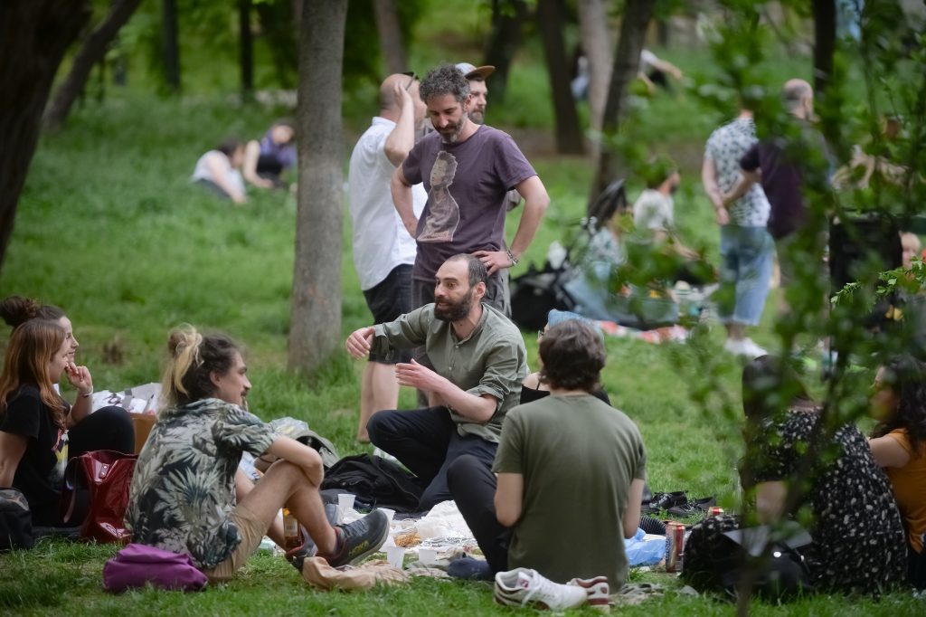 Un grup de tineri se află la picnic în Parcul Cișmigiu din București
