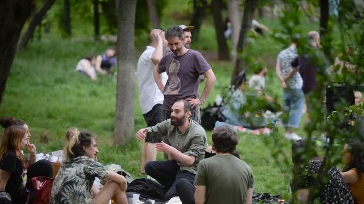 Un grup de tineri se află la picnic în Parcul Cișmigiu din București