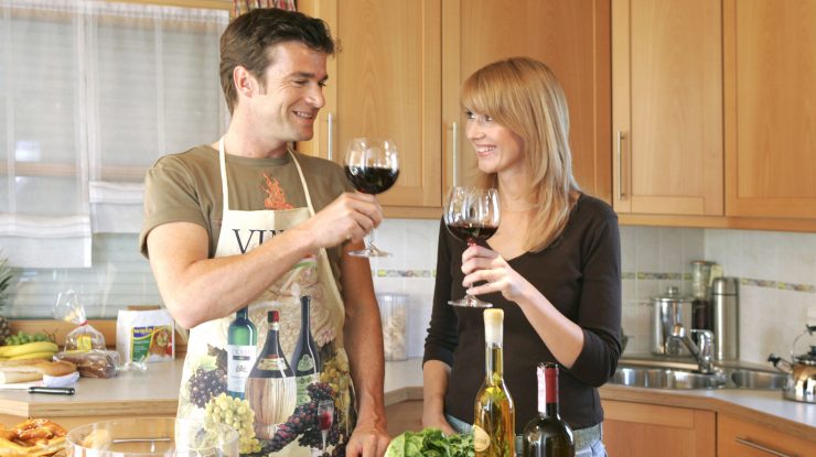 Un cuplu bea vin acasă, în bucătărie.