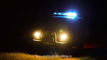 masina a politiei de frontiera, noaptea, cu farurile aprinse.