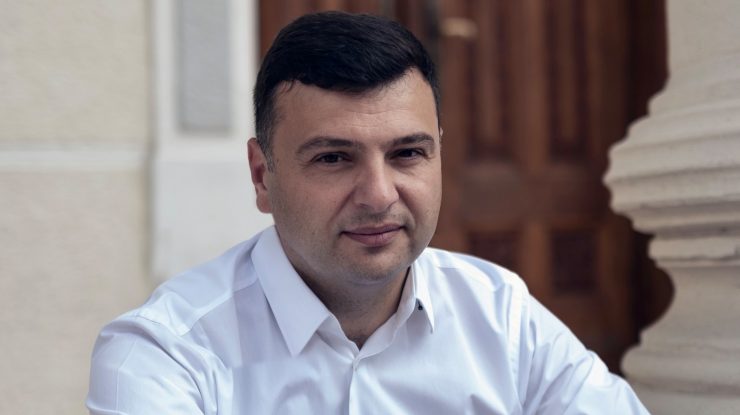 Sergiu Bîlcea, deputat PNL, pozând pe scările unei clădiri.