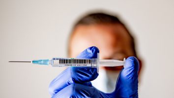 Medic care ține între degete o seringă cu ser anti-COVID.