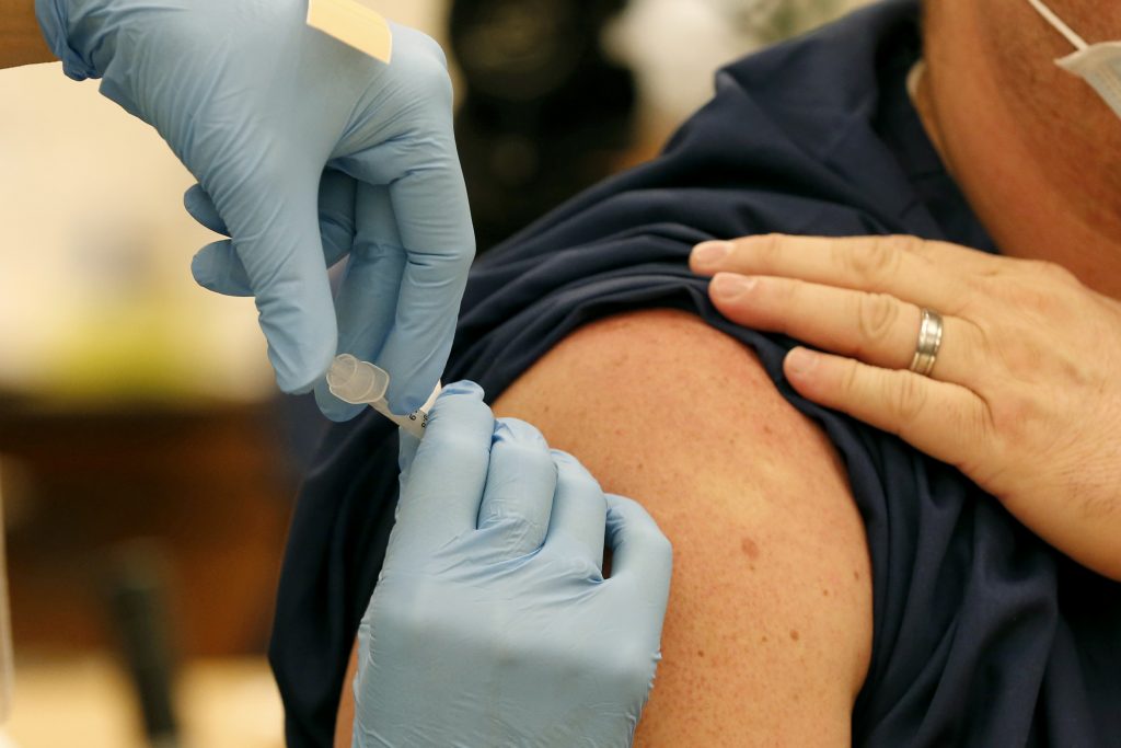 O persoană primește vaccinul anti-COVID.