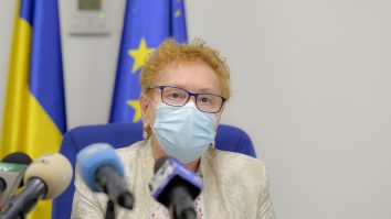 renate weber cu masca pe fata intr-o conferinta.