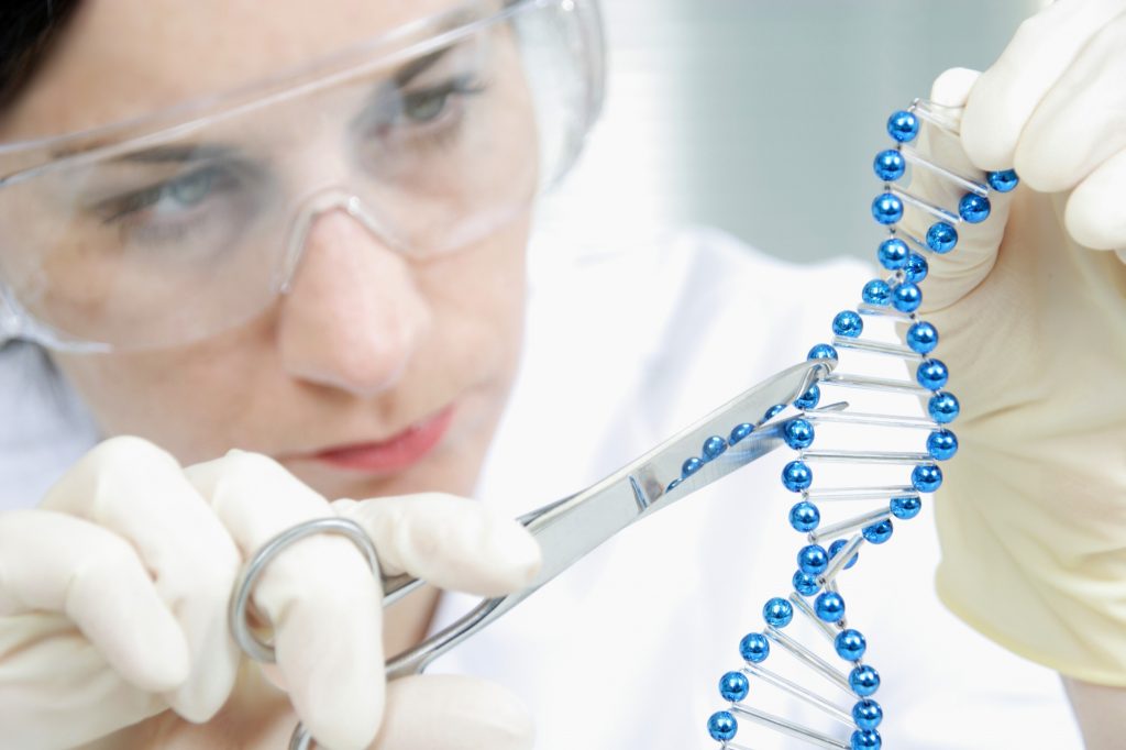 Femeie în laborator care lucrează cu un obiect care întruchipează ADN-ul.