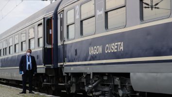 un controlor sta langa un tren de la cfr.