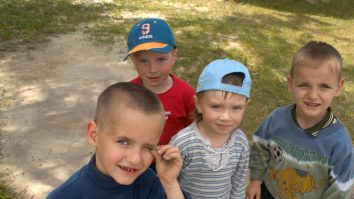 Copii orfani care se uită triști spre aparatul de fotografiat.