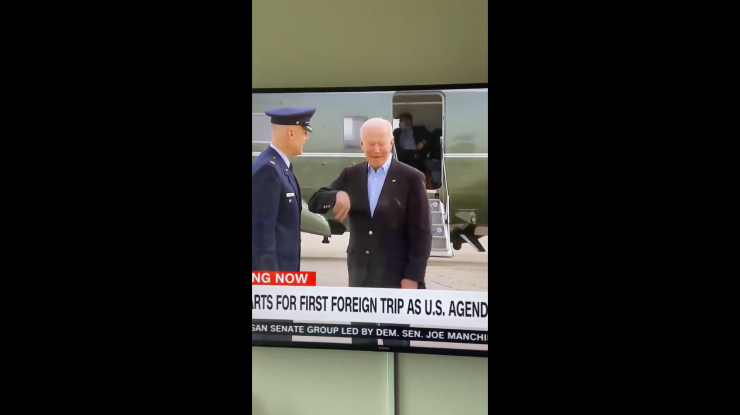 Joe Biden în fața avionului său în timp ce este atacat de o lăcustă.