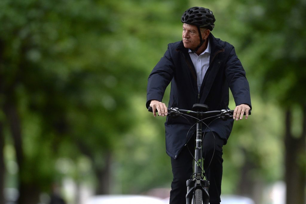 Klaus Iohannis merge pe bicicletă în parc.