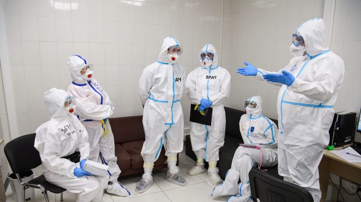 Medici îmbrăcați în echipamente COVID-19.