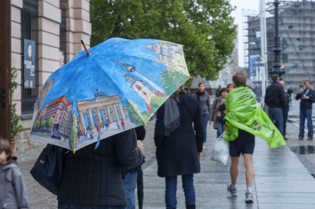 Oamenii care merg cu umbrela prin ploaie.