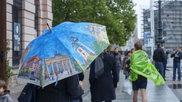 Oamenii care merg cu umbrela prin ploaie.