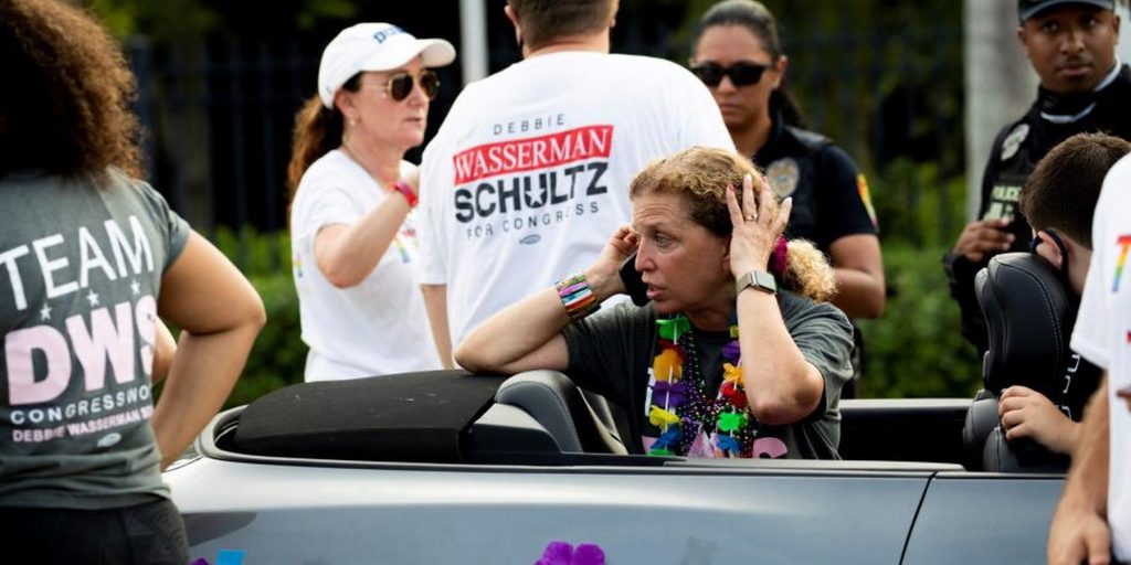 Femeie care sună după ajutor după un accident petrecut în timpul unei parade LGBT.