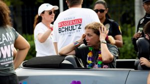 Femeie care sună după ajutor după un accident petrecut în timpul unei parade LGBT.