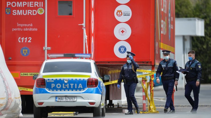 Polițiști lângă o mașină de poliție și o autospecială SMURD.