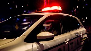 politisti intr-o masina de politie, noaptea.