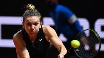 Simona Halep lovește cu racheta într-o minge de tenis.